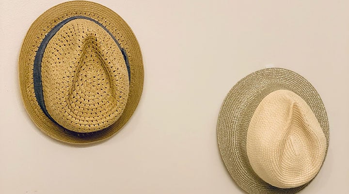fedora hats displayed on a wall